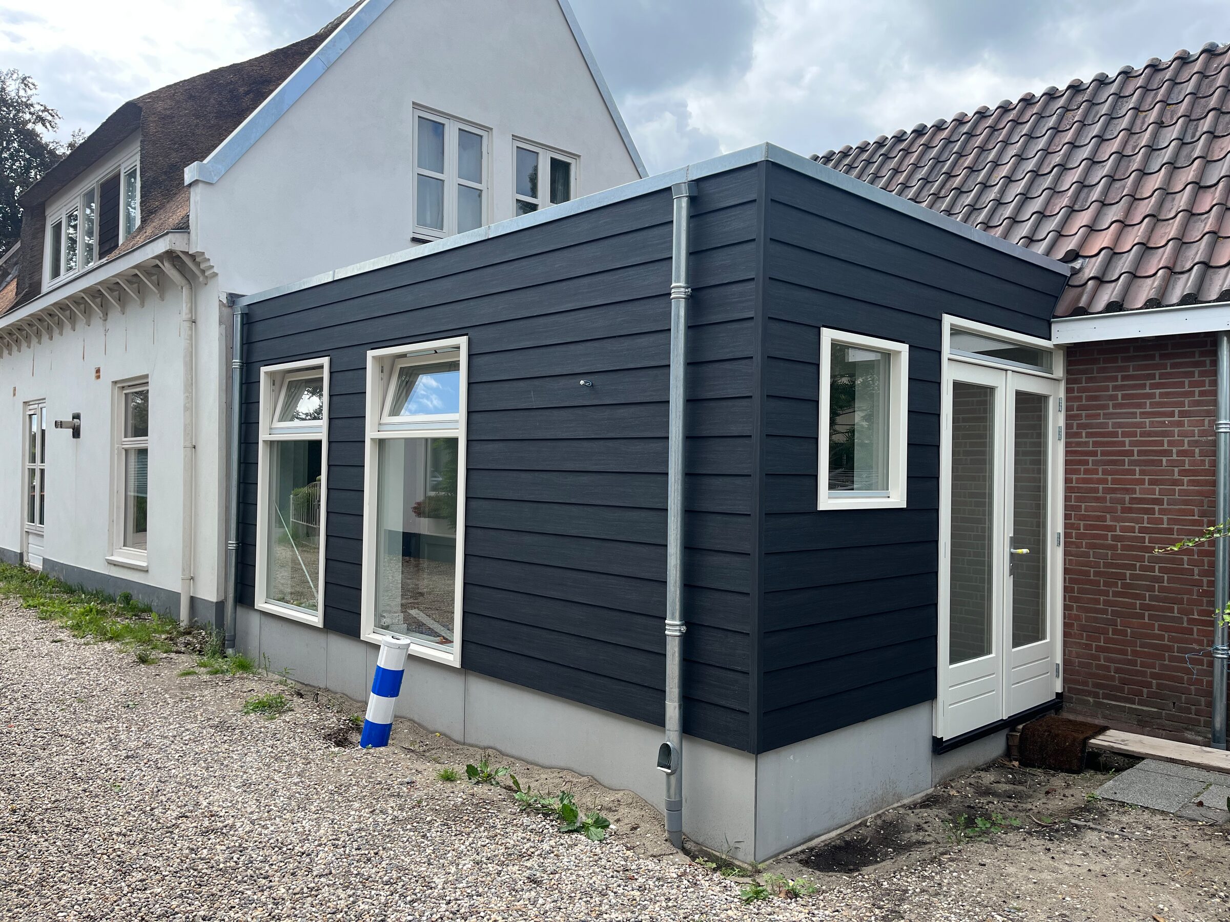 Aanbouw met zwarte gevel en openslaande deuren, door LBH Bouw