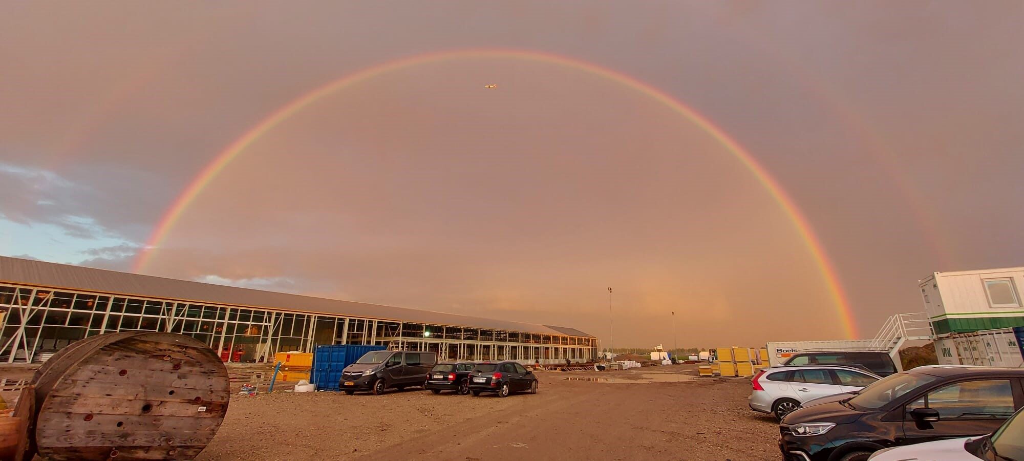 Nieuwbouw bedrijfspand van Daan Kromhout & Zn. in Rijsenhout, gebouwd door LBH Bouw: bouwplaats met regenboog