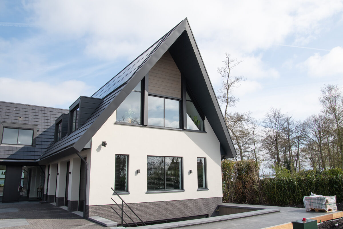 Luxe vrijstaande villa aan het water, gebouwd door LBH Bouw: zijgevel met grote raampartijen