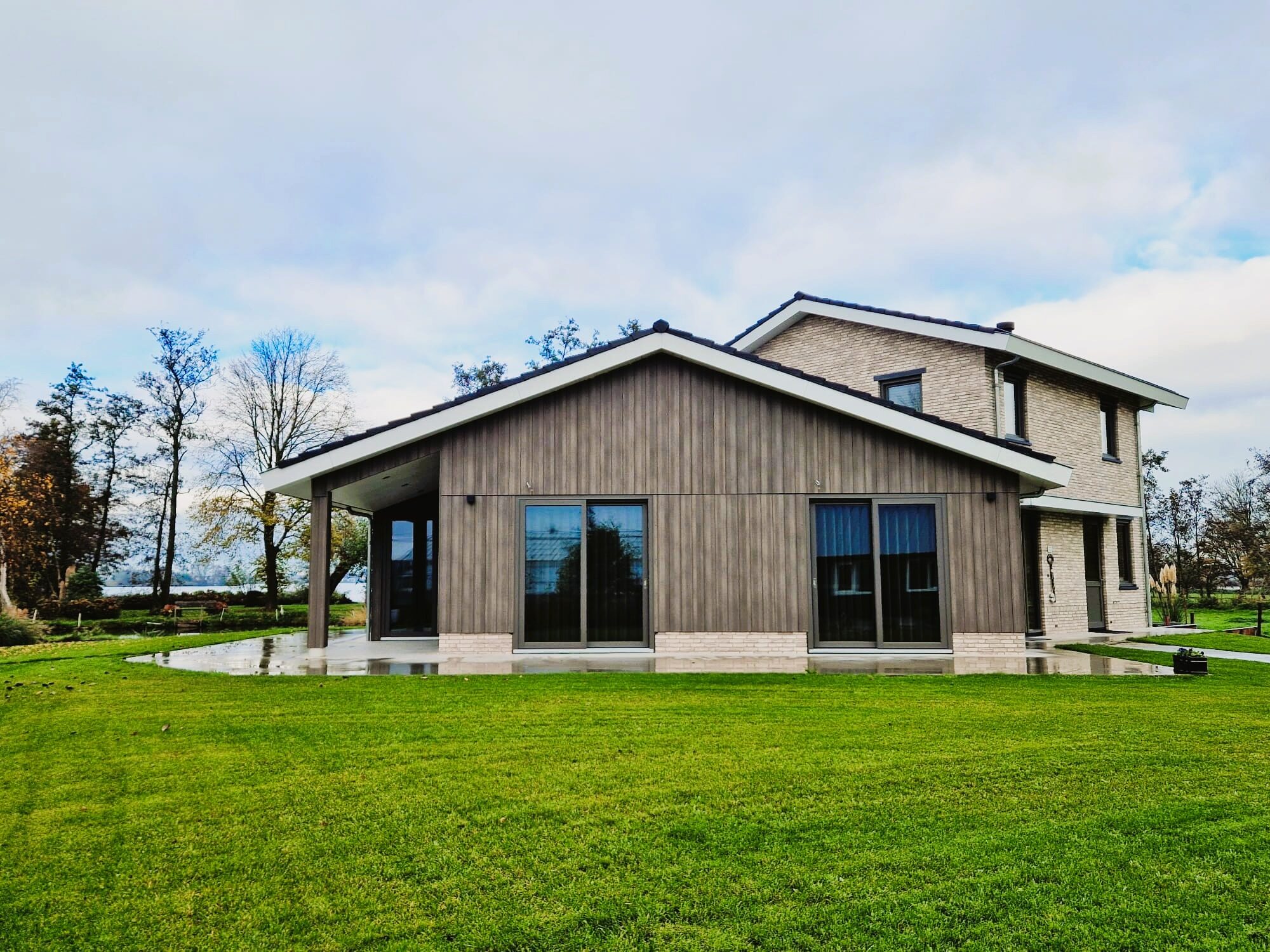 Luxe woning aan het water, gebouwd door LBH Bouw: tuinzijde met houten gevel