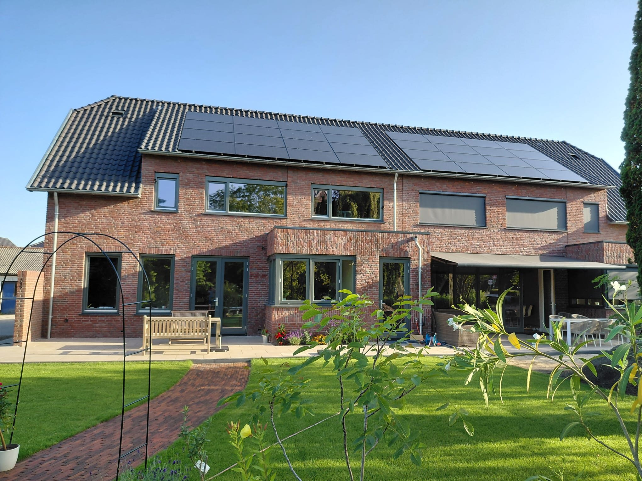 Bakstenen woning met zonnepanelen op het dak, een project van LBH Bouw