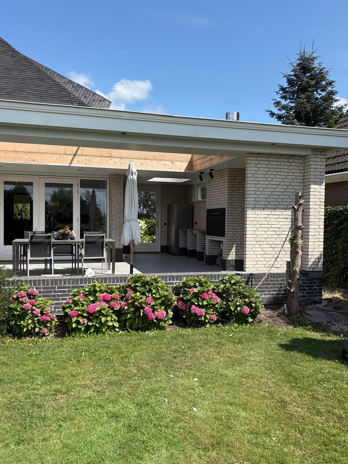 Overkapping aan de tuinzijde van een woning, gebouwd door LBH Bouw