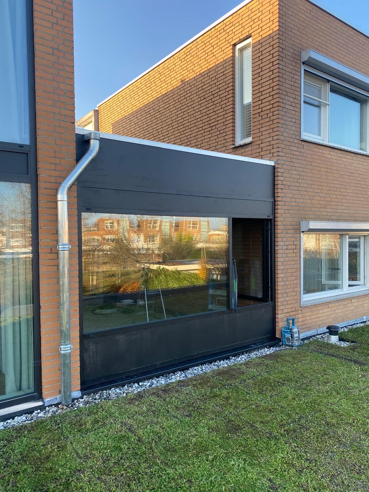 Uitbouw met grote glaspartij aan een bakstenen woning, door LBH Bouw