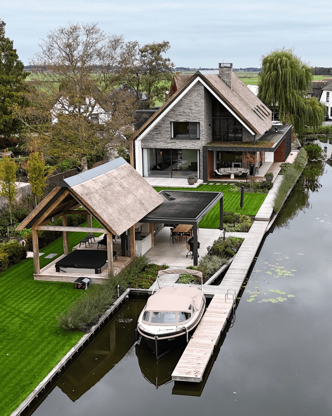 Villa aan het water, gebouwd door LBH Bouw: van bovenaf gezien met botenhuis en steiger