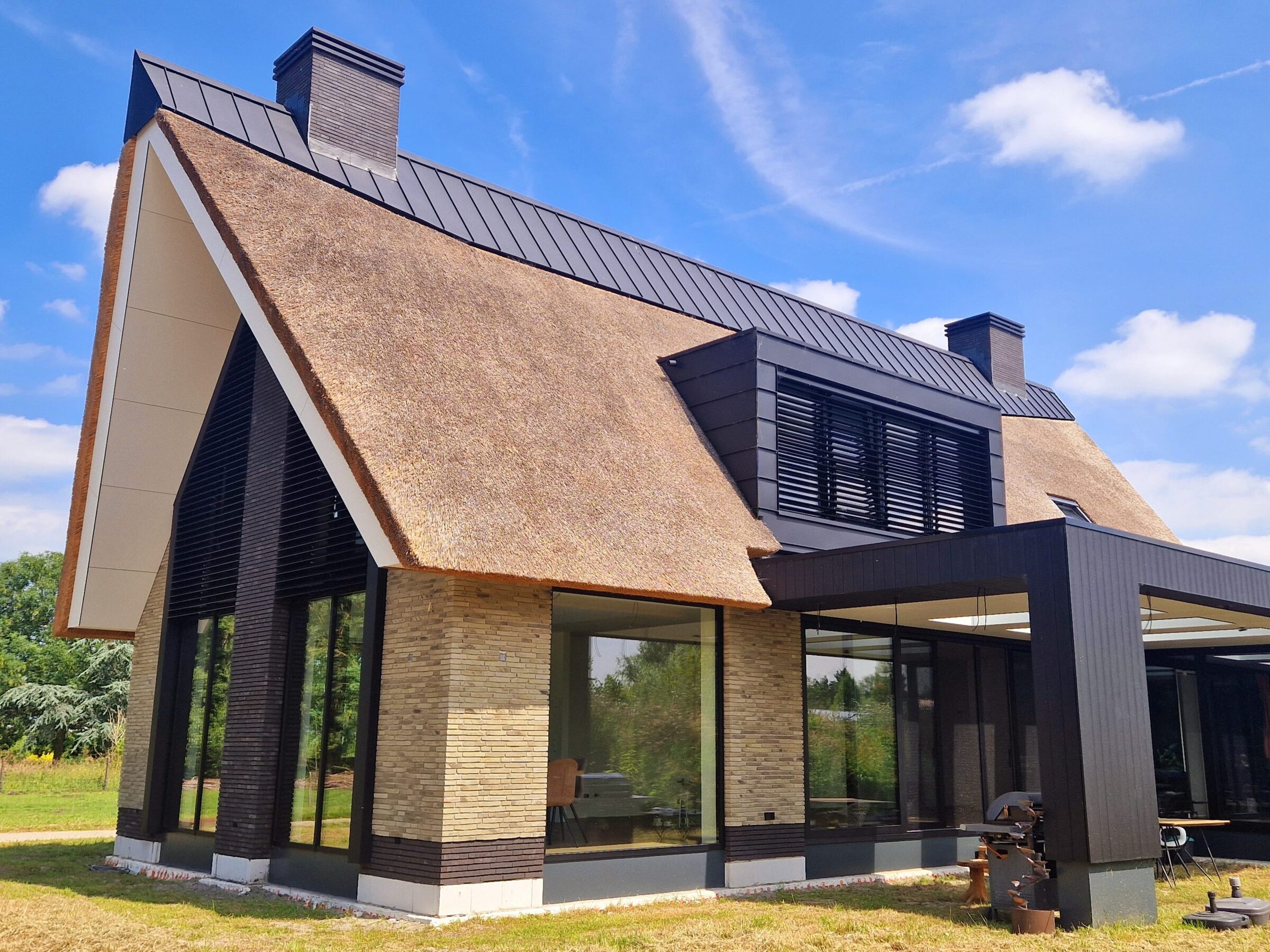 Villa met rieten dak, gebouwd door LBH Bouw: hoekaanzicht met overkapping