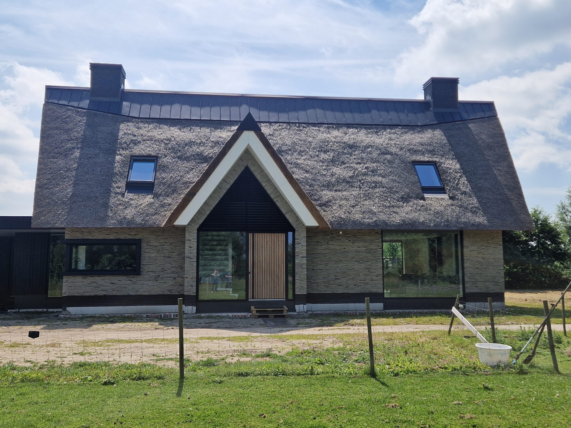 Villa met rieten dak, gebouwd door LBH Bouw: voorgevel met houten voordeur en dakramen