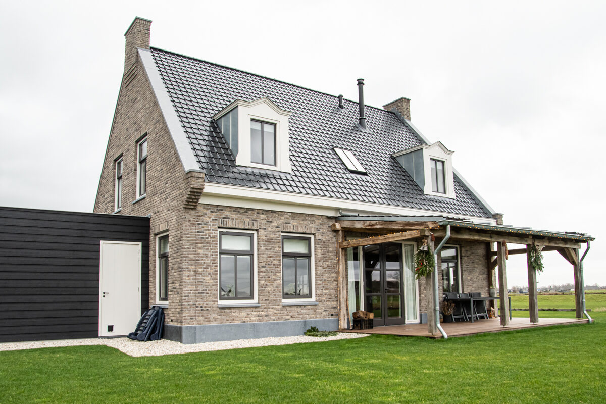 Vrijstaande woning met dakkapellen, gebouwd door LBH Bouw: achterzijde met houten overkapping en berging