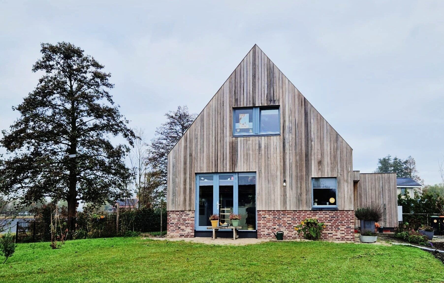 Vrijstaande woning aan het water met houten gevel, gebouwd door LBH Bouw: achtergevel met tuin